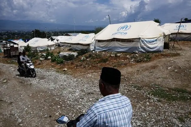 Warga melewati tenda yang disediakan UNHCR untuk korban gempa bumi dan tsunami yang melanda daerah tersebut setahun yang lalu di Balaroa di Palu, Sulawesi Tengah, Indonesia pada 29 September 2019. 