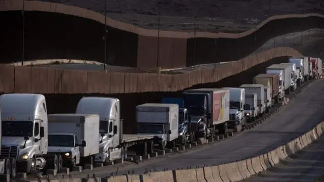 Una hilera de camiones circula en la frontera entre México y Estados Unidos.