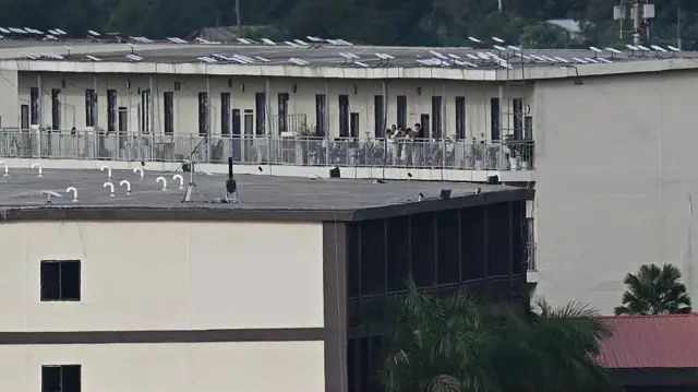 На фотографии изображены люди на балконе здания, на крыше которого, установлены спутниковые антенны Starlink, в комплексе KK Park в восточном городке Мьявади в Мьянме 17 сентября 2025 года.