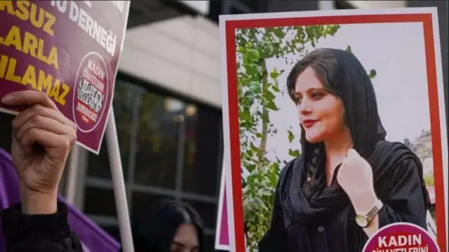 ผู้ประท้วงถือรูปของมาห์ซา อามินี 