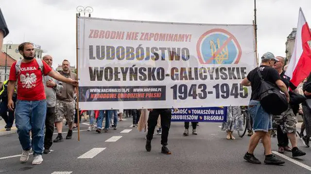 Протестувальники несуть банер з написом "Волинсько-галицький геноцид 1943-45 років" із зображенням перекресленого українського тризуба під час демонстрації у Варшаві, Польща, 12 липня 2026 року