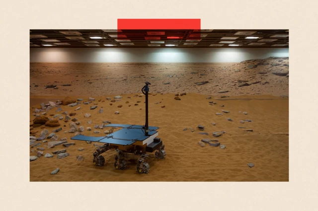 Un prototype fonctionnel du rover ExoMars sur une surface jaune-orange ressemblant à du sable