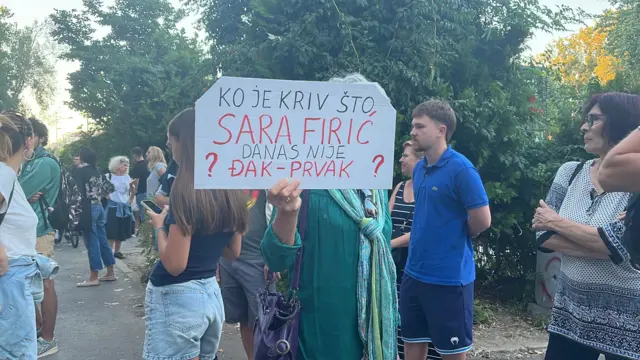 Жена у руци држи транспарент