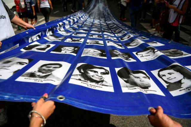 Pancartas con fotografías de desaparecidos entre 1976 y 1983 durante una manifestación en Argentina en 2018. 