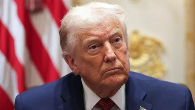 Trump, omuz hizasından kesilen bu fotoğrafta lacivert takım elbisesi ve arka planda ABD bayrağının bir bölümüyle görünüyor. 