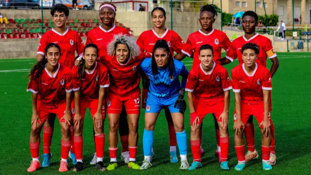 Les joueuses du FUS Rabat s'alignent pour une photo d'équipe avant un match. Les dix joueuses de champ portent un maillot rouge et la gardienne de but un maillot bleu.