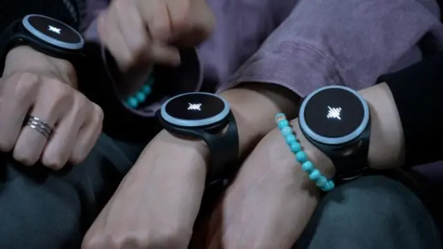 Members showing their wrists with smarphones