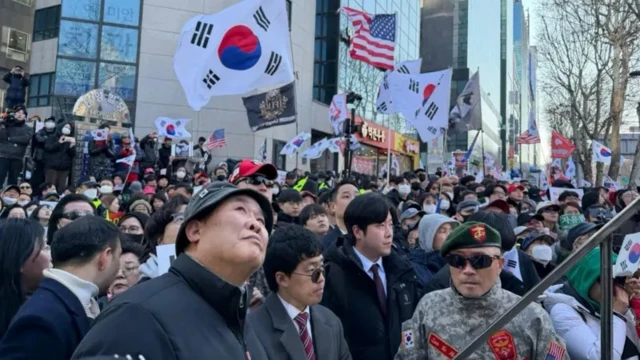 Большая толпа людей с флагами Южной Кореи и США