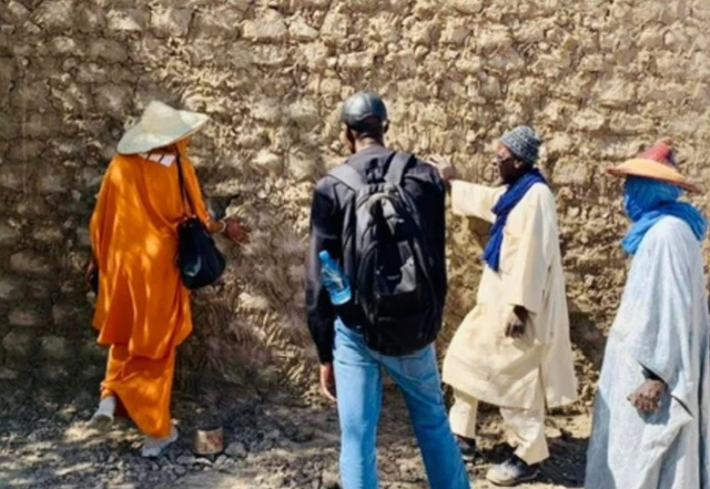 Mariam Keita touchant un mur, lors de la restauration des mausolées de Tombouctou.