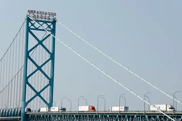 Una foto del puente Ambassador, mientras pasan varios camiones sobre él.