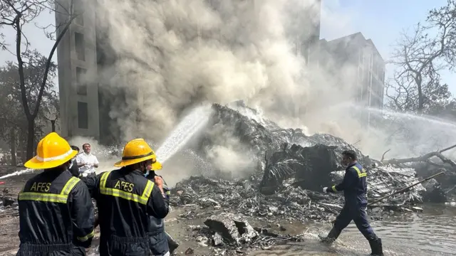 Firefighters tackle plumes of smoke at the scene of the crash Firefighters tackle plumes of smoke at the scene of the crash