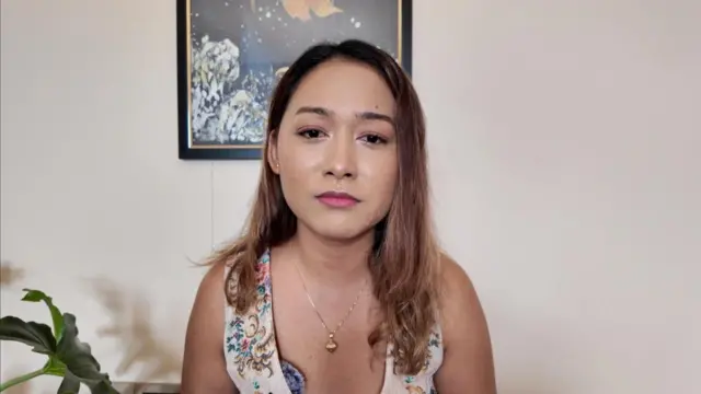 मंजिता मानन्धर फूड भ्लगर हुन्। पृष्ठभूमिमा एउटा चित्रकला र छेउमा एउटा बिरुवासहितको उनको घरमा लिइएको तस्बिर।