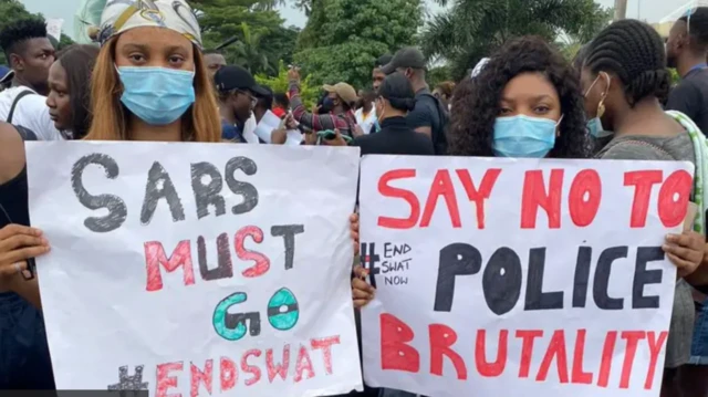 Picture of two women wearing nose masks displaying placards during the End SARS nationwide protest in Nigeria, October 2020.