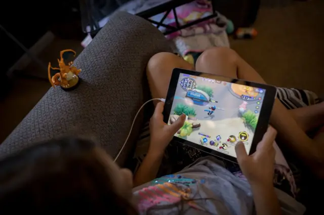Uma criança jogando um jogo no iPad
