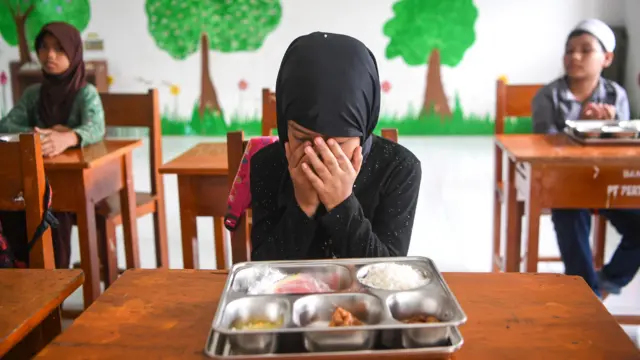 Siswa berdoa sebelum menyantap makanan dari porsi makan bergizi gratis (MBG) di Madrasah Ibtidaiyah (MI) Darul Furqan, di Sebatik Tengah, Nunukan, Kalimantan Utara, Rabu (22/7/2026).