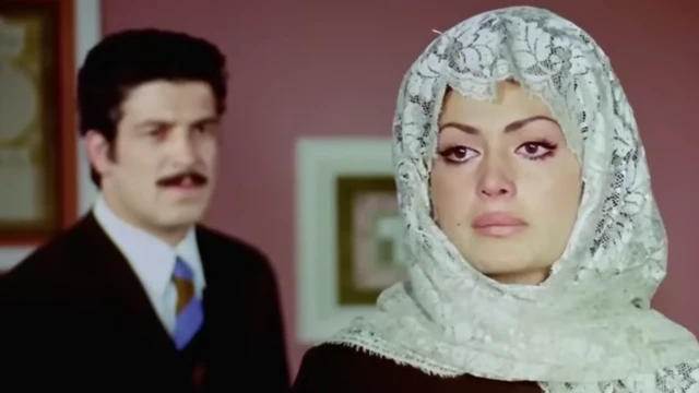 Birleşen Yollar filminden bir sahne. Önde başörtülü olarak Türkan Şoray arkada ise İzzet Günay görülüyor.
