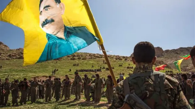 نیروهای پکک با پرچمی که تصویر اوجالان را دارد