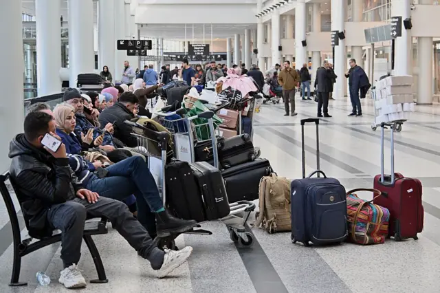 Beyrut'taki Rafik Hariri Uluslararası Havalimanı'nda çok sayıda insan valizleriyle bekliyor.