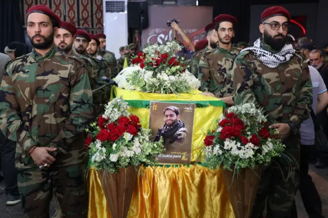 সহযোদ্ধা কাসেম ইব্রাহিম আবু তাম, যিনি দক্ষিণ লেবাননে ইসরায়েলি সৈন্যেদের গুলিতে নিহত হন, তাঁর কফিনবন্দি দেহের পাশে দাঁড়িয়ে হেজবুল্লাহ সদস্যরা। 