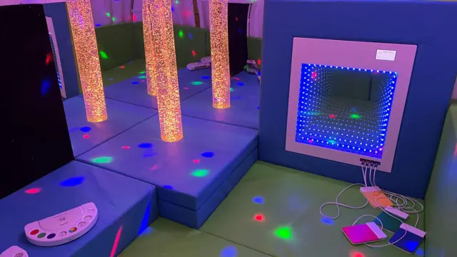 Un espacio sensorial: suelos y cojines suaves, luces de colores brillantes, pantallas y purpurina.