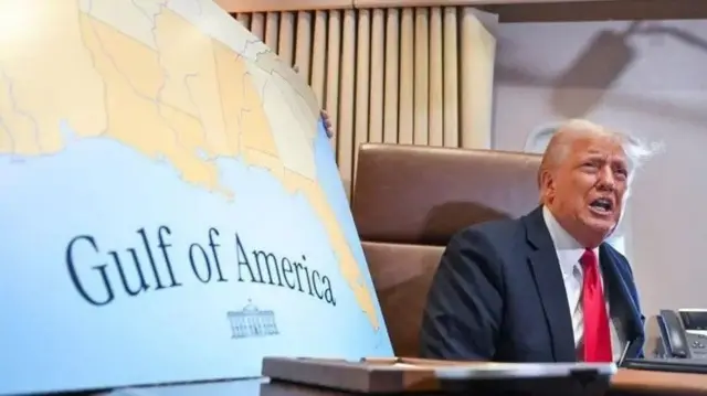 Trump ao lado de pôster com mapa americano e dizeres "Golfo da América"