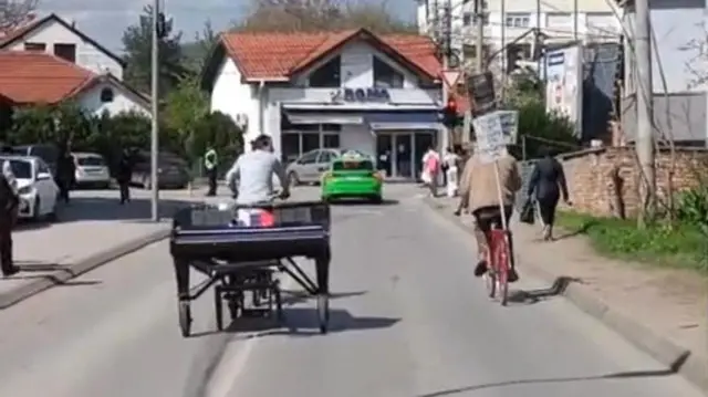 Davide Martelo vozi biciklo i vuče klavir, do njega na bicikli stariji Nišlija koji mu pomaže da se snađe u gradu