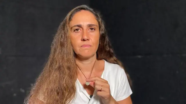 Tracey Najjar tenant un pendentif