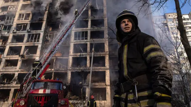 Пожарный на фоне горящего здания