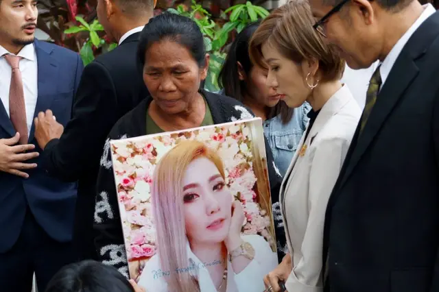 Ibu Siriporn, Thongpin Kiatchanasiri, memegang foto mendiang putrinya.