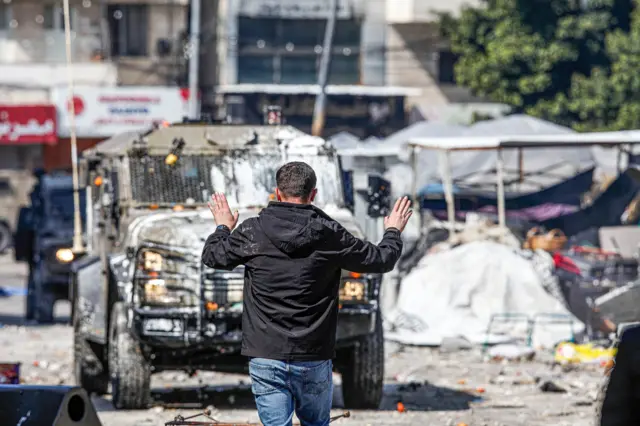 Jovem palestino gesticulatem como processar casa de apostasfrente a veículos do exército israelense durante confrontotem como processar casa de apostasfeira no centro históricotem como processar casa de apostasNablus, na Cisjordânia ocupada