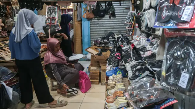Calon pembeli memilih sepatu yang dijual di Pasar Kranggot, Kota Cilegon, Banten, Selasa (6/1/2026).
