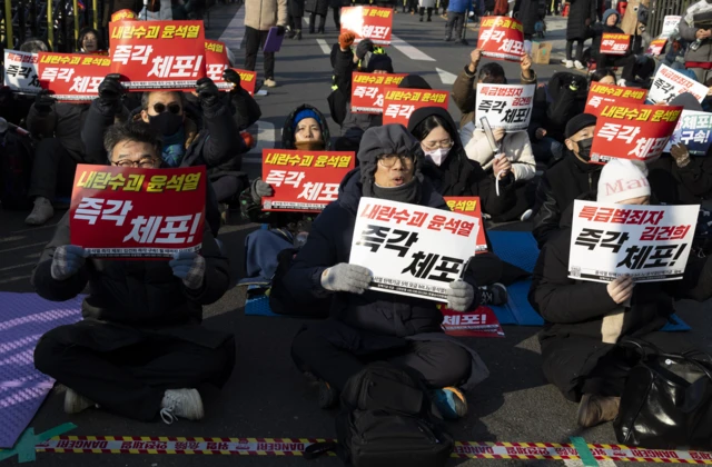 윤석열 대통령 관저 주변에 모인 집회자들이 윤석열 대통령 체포를 요구하는 펫말을 들고 있다