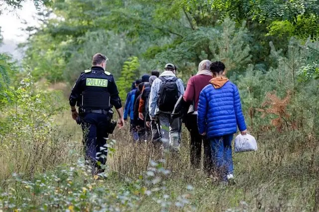 поліцейський і мігранти, кордон Польщі, переїзд до Німеччини  