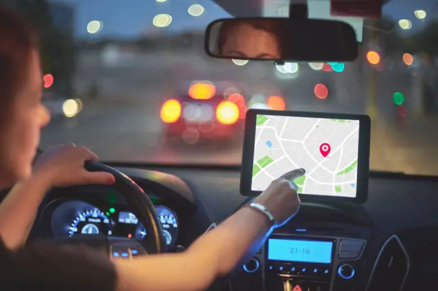 Mulher olha navegação de GPS em um carro