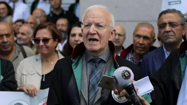 İbrahim Kaboğlu mikrofonlara konuşuyor, arkasında kalabalık