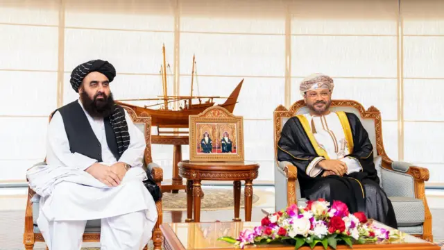 از راست، وزیر خارجه عمان که با چپن سیاه و زرد و لباس سفید و لنگی مخصوص و در کنار او امیرخان متقی وزیر خارجه حکومت طالبان با لنگی و واسکت سیاه و لباس سفید.