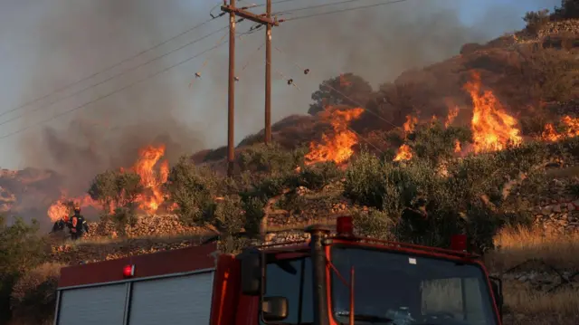 Пожарная машина на фоне горящего склона