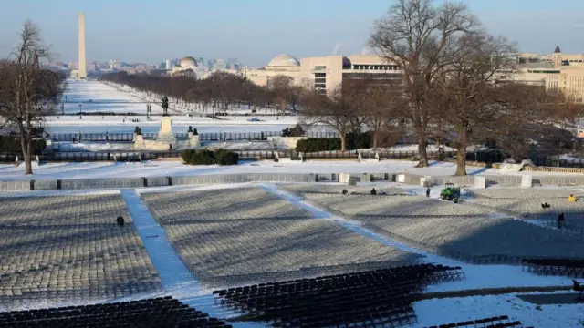 Workers set up rows of chairs on the lawn of the Capitol building and the national mall