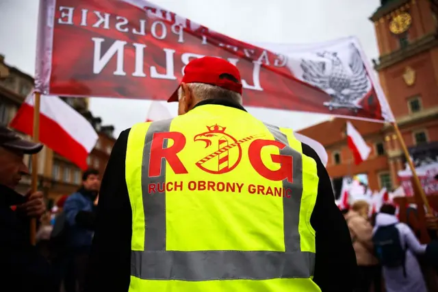 Mężczyzna ubrany w żółtą kamizelkę z napisem „Ruch Obrony Granic” uczestniczy w proteście przeciwko nielegalnej migracji oraz umowie UE–Mercosur