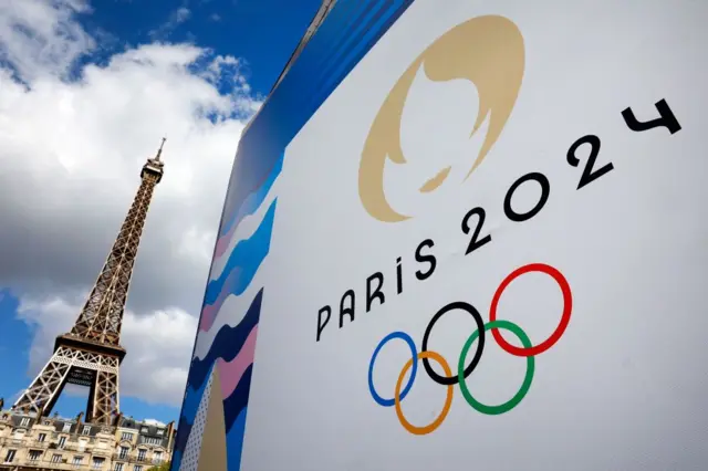 A torre Eiffel junto a um cartaz com o logo dos Jogos Olímpicos