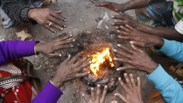 আগুন পোহাচ্ছে শীতার্ত মানুষ