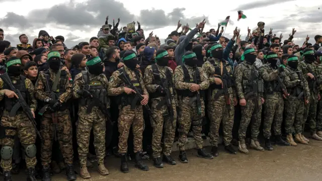 መሳሪያቸውን ይዘው የደንብ ልብሳቸውን ለብሰው በመደዳ የቆሙ የሐማስ ወታደሮች