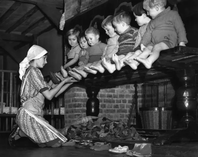 أطفال صغار أُجلوا من لندن خلال فترة القصف الجوي (البلتز) يخضعون لفحص أقدامهم في مسكنهم الجديد.