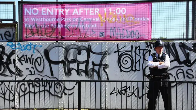 Полицейский у забора, изукрашенного граффити