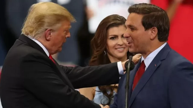 Трамп менен Десантис сахнада бири-бирине жылмайып, кол кысышууда