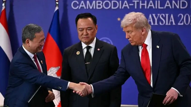 Presiden AS, Donald Trump, menyalami Perdana Menteri Kamboja, Hun Manet, yang disaksikan Perdana Menteri Thailand, Anutin Charnvirakul (tengah), pada Minggu (26/10).
