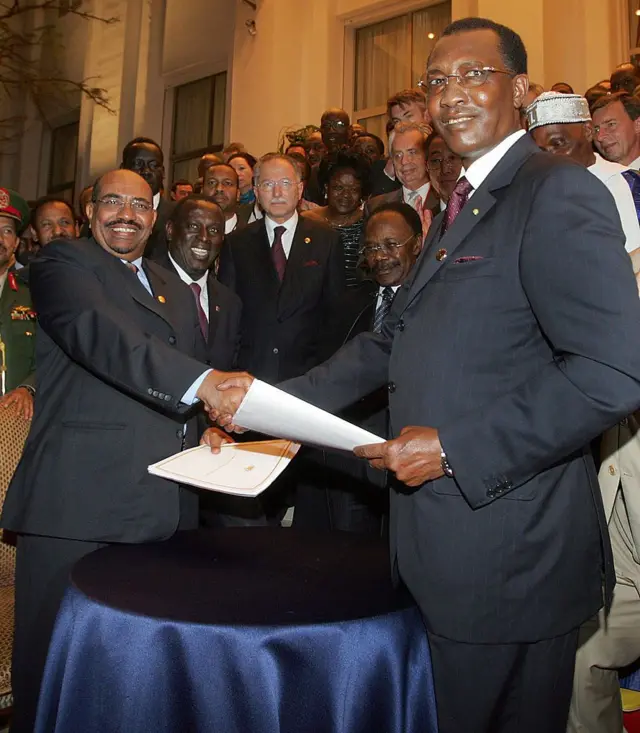 Le président tchadien Idriss Deby (D) serre la main du président soudanais Omar al-Beshir (G) après avoir signé un pacte de non-agression au palais présidentiel sénégalais, le 14 mars 2008 à Dakar.