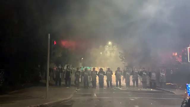 Полицейские стоят, готовясь к нападениям.