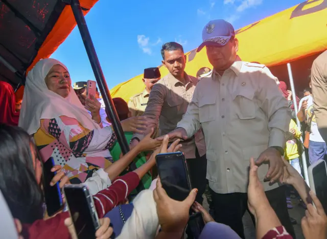 Presiden Prabowo Subianto menyapa warga di posko pengungsian banjir di Kasai, Padang Pariaman, Sumatera Barat, Senin (1/12/2025). Kunjungan presiden memastikan kondisi warga terdampak bencana di pengungsian serta mendistribusikan bantuan dan berjanji akan mengusut tuntas penyebab banjir bandang dan longsor yang melanda Sumatera Barat dan sekitarnya. 