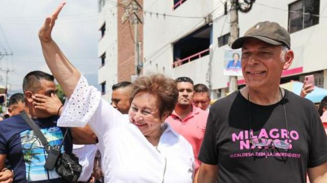 La alcaldesaMilagro Navas (centro, con camisa blanca), de Arena, de la mano de su marido Al Quintanilla el 3 de marzo de 2024, durante la jornada electoral municipal de El Salvador.
